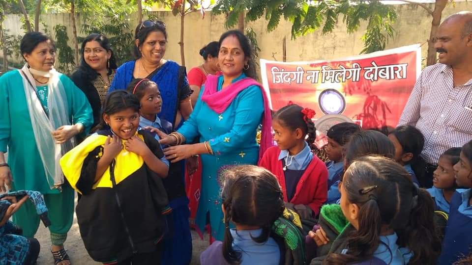 बच्चों को सामग्री वितरित करते हुए संस्था की टीम
